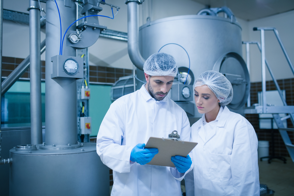 Food technicians working together in a food processing plant and the best mixing equipment Food technicians working together in a food processing plant and the best mixing equipment